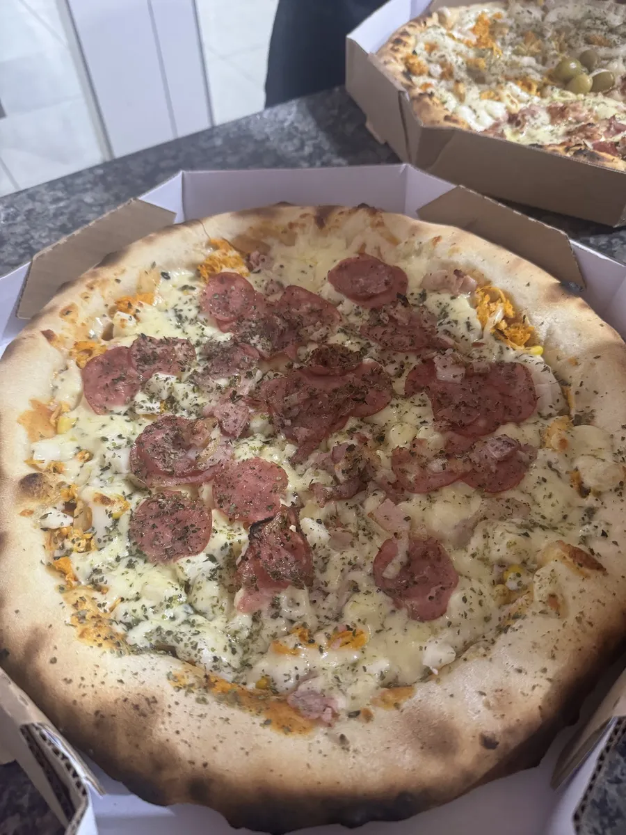 Pizza artesanal da Pepsi Pizza na caixa de entrega, com calabresa, queijo derretido e ervas